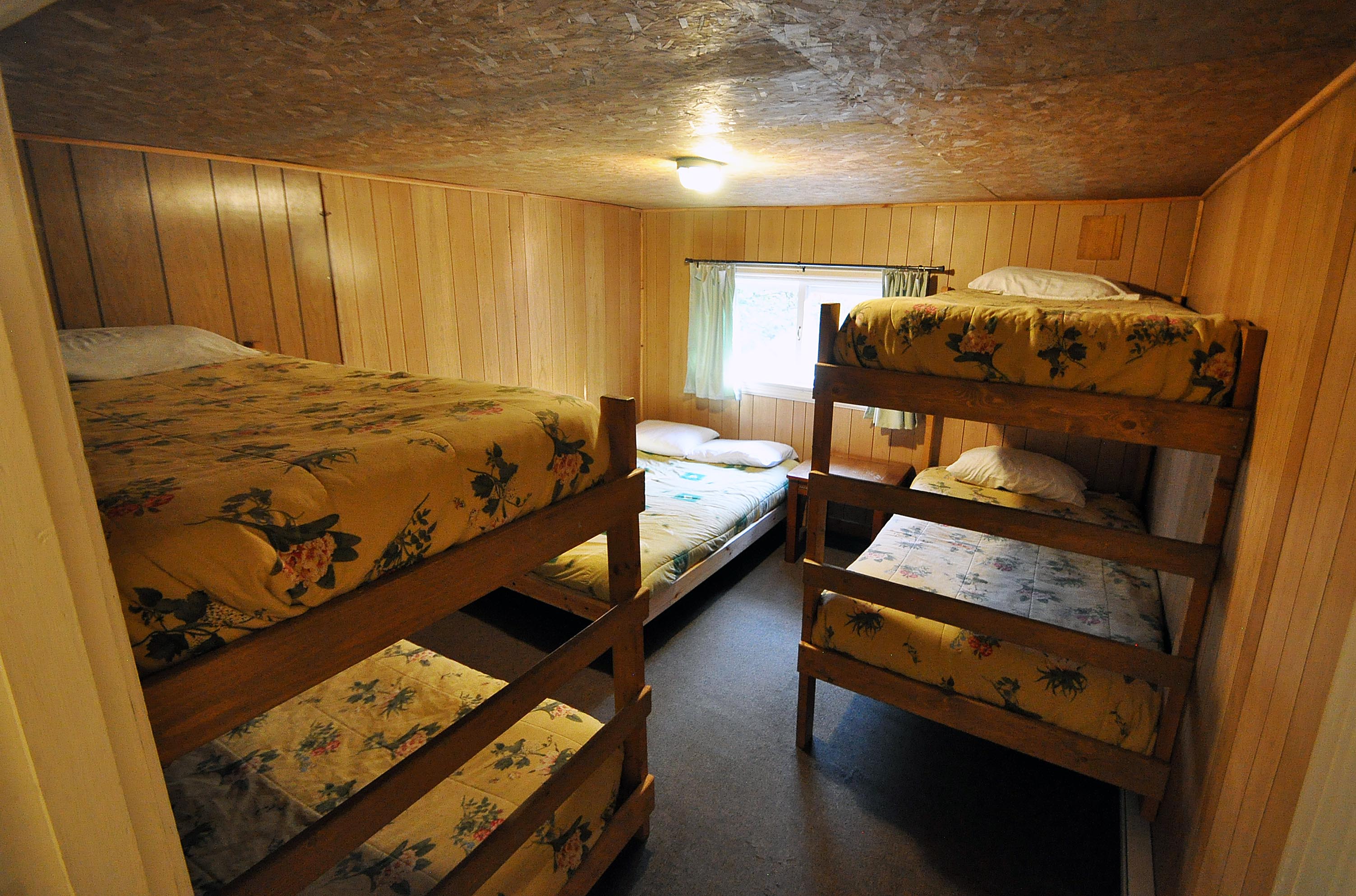 Cabin 15 - bedroom with two bunk beds and single bed.