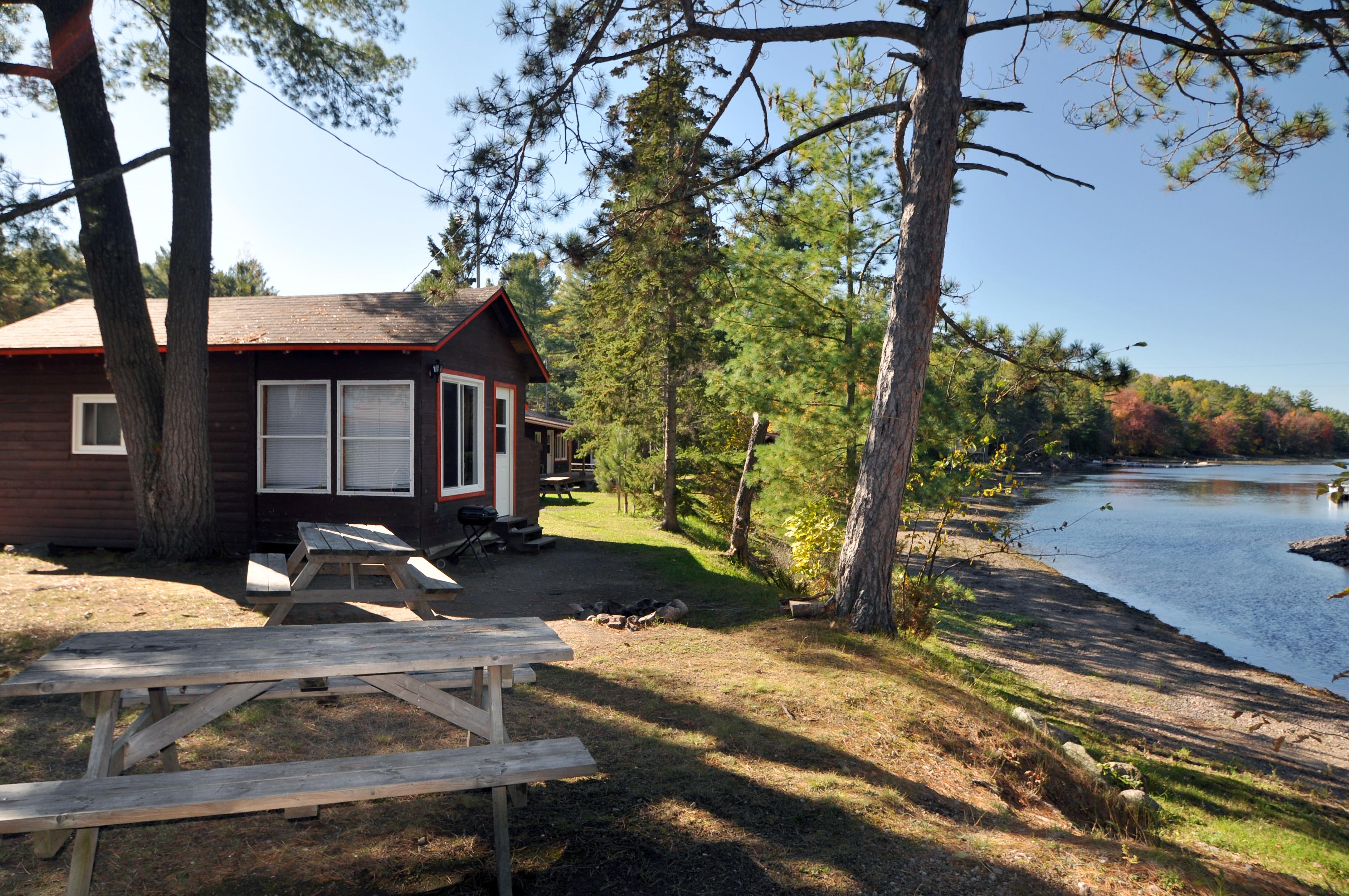 Cabin 3 - Exterior. Two picnic tables and view of the river.