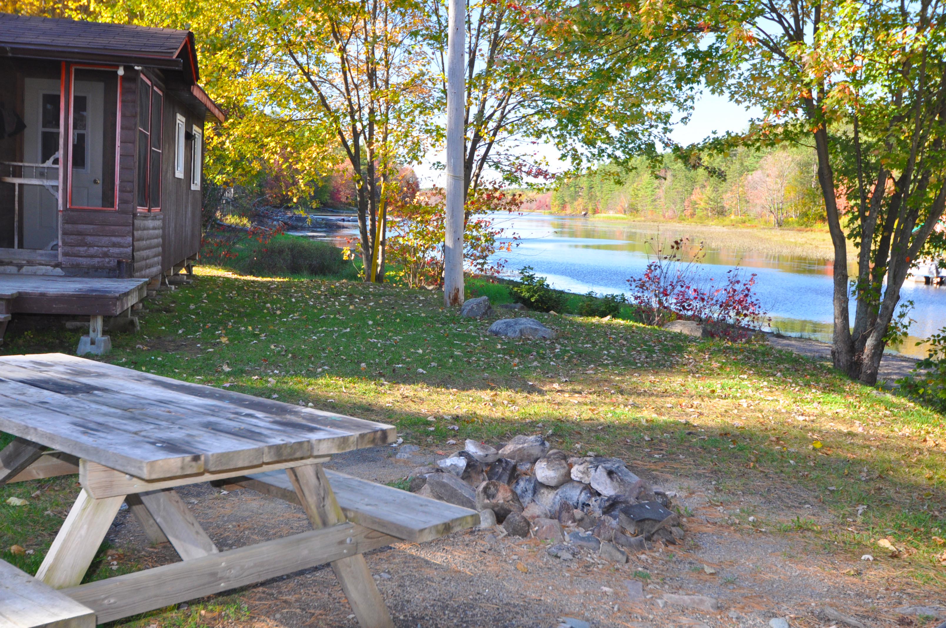 Cabin 7 view of river, fire pit and picnic table.