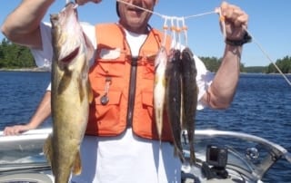 John holding several fish on a line.